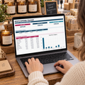 Market vendor using the Booth Expense Tracker dashboard at a handmade candle and soap booth