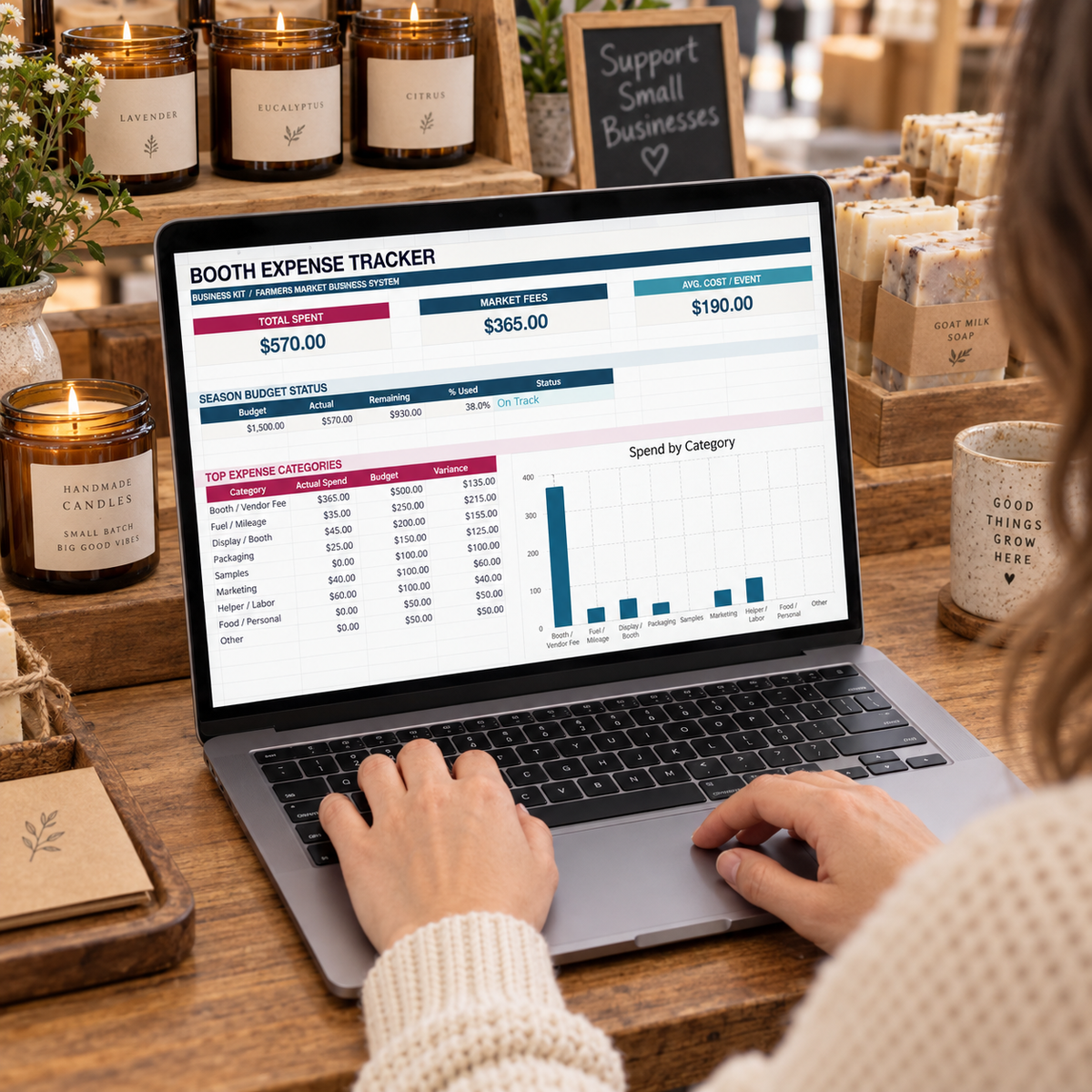 Market vendor using the Booth Expense Tracker dashboard at a handmade candle and soap booth